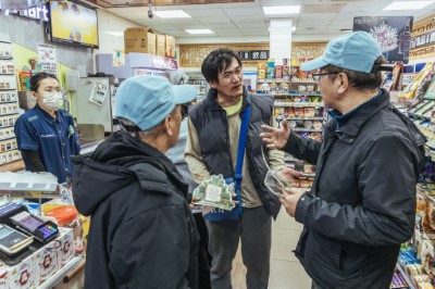 林業保育署臺中分署梨山工作站李彥興主任及梨山里賴聖功里長於全家便利商店和平梨山店與在地居民說明改良式獵具推廣平台的換發方式